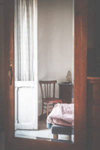 Ein Stuhl, eine Tür und ein Bett, eine Zimmereinrichtung der 50'er / 60'er Jahre im Spiegel betrachtet, Ein Stuhl, eine Tür und ein Bett, eine Zimmereinrichtung der 50'er / 60'er Jahre im Spiegel betrachtet,